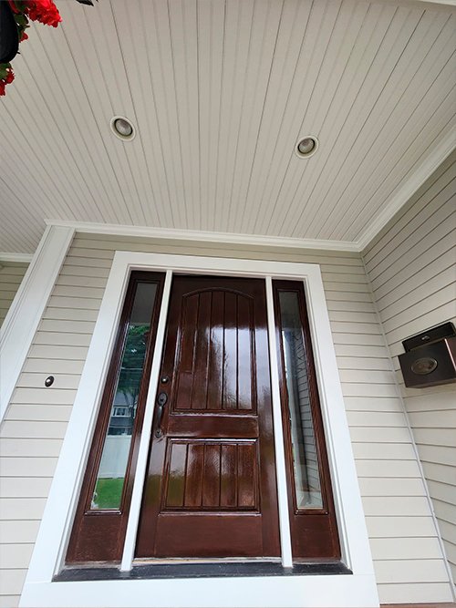 Exterior carpentry repair and freshly painted wood door